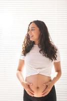 mulher grávida tocando sua barriga. gravidez e licença maternidade foto