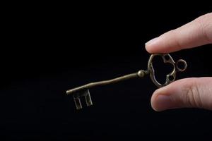 mão segurando uma chave decorativa com estilo retrô