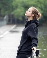 retrato de jovem sorrindo. mulher bonita em pé uma pessoa ao ar livre. uma mulher alegre, de cabelos castanhos compridos, olhos castanhos tem uma emoção positiva liberdade de atividade de lazer em um parque natural. foto