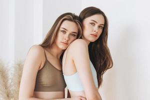 modelos de beleza da moda duas irmãs gêmeas lindas garotas com cabelos longos no esporte cueca sem costura com nervuras no estúdio brilhante foto