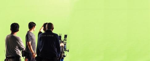 câmera e estúdio de tela verde em vista panorâmica e homem trabalhando ou filmando ou gravando ou filmando. foto