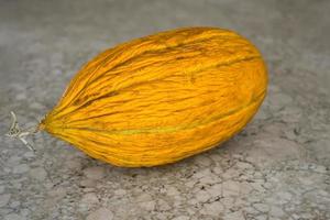 melão amarelo suculento em uma mesa de pedra, close-up, foco seletivo na baga, a ideia de anunciar frutas orgânicas do mercado do fazendeiro. conceito de plano de fundo ou artigo foto