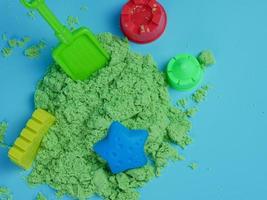 conjunto de brinquedos de areia verde e estampas isoladas em fundo azul foto