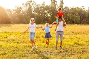 jovem família feliz com dois filhos no parque de verão foto