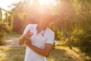 um homem usando um chapéu de cowboy, jeans e um cinto. foto