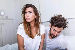 casal com problemas de desacordo na cama. casal frustrado discutindo e tendo problemas de casamento, jovem casal em uma discussão na cama no quarto foto