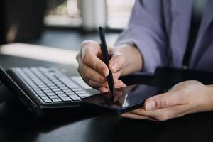 colegas asiáticos homem e mulher discutindo e trabalhando com laptop na mesa de escritório no escritório foto