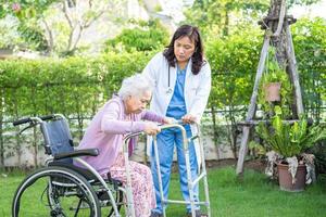 médico, ajuda e cuidado paciente asiático sênior ou idosa senhora sentada na cadeira de rodas no parque na enfermaria do hospital, conceito médico forte e saudável. foto