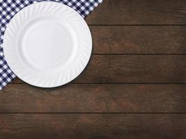 toalha de mesa azul na gaiola e prato vazio no fundo da mesa de madeira foto