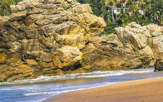 grandes ondas de surfista e rochas na praia puerto escondido méxico. foto