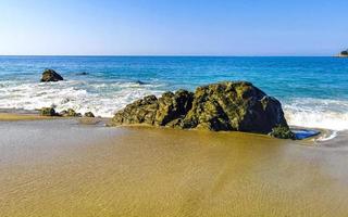 grandes ondas de surfista e rochas na praia puerto escondido méxico. foto