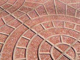 vista diagonal em um padrão arredondado em um pavimento de pedra vermelha foto