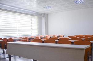sala de aula vazia com cadeiras e mesas laranja