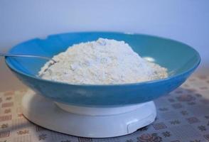 prato de farinha em uma balança de cozinha foto