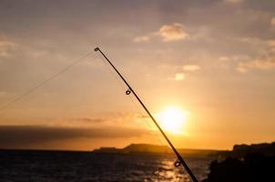 carretel de pesca sobre o pôr do sol foto