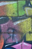 fragmento de desenhos de grafite. a velha parede decorada com manchas de tinta no estilo da cultura da arte de rua. textura de fundo multicolorida foto