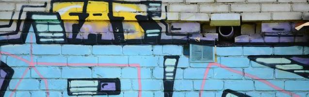fragmento de desenhos de grafite. a velha parede decorada com manchas de tinta no estilo da cultura da arte de rua. textura de fundo colorida em tons frios foto