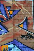 fragmento de desenhos de grafite. a velha parede decorada com manchas de tinta no estilo da cultura da arte de rua. textura de fundo colorido em tons quentes foto