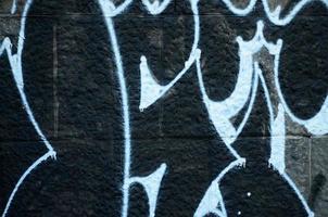 fragmento de desenhos de grafite. a velha parede decorada com manchas de tinta no estilo da cultura da arte de rua. textura de fundo colorido foto