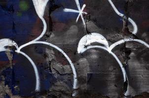 um fragmento de desenho de graffiti com contornos, aplicado na parede com o auxílio de latas de tinta aerossol sobre as áreas de preenchimento coloridas. textura de fundo de arte de rua e vandalismo foto
