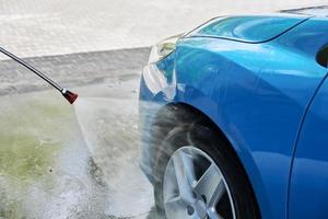 carro de limpeza com água de alta pressão na estação de lavagem de carros foto