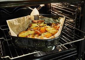 batatas com batata doce são assadas no forno na assadeira foto