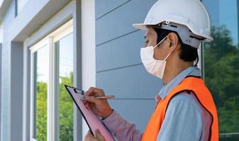 inspetor ou engenheiro está verificando e inspecionando o prédio ou casa usando a lista de verificação. engenheiros e arquitetos trabalham na construção da casa antes de entregá-la ao proprietário. foto