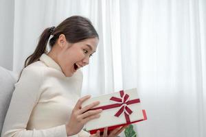 mulher bonita asiática se sente surpresa e parece interessada dentro da caixa de presentes. linda garota animada caixa de presente aberta. aniversário, celebração, Natal, festival de ano novo, obrigado, comemoro, dia dos namorados, aniversário foto