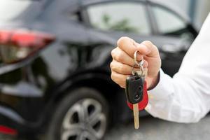 alugar, alugar carro, vender, comprar. o gerente da concessionária envia as chaves do carro para o novo proprietário. vendas, empréstimo de crédito financeiro, aluguel de veículo, seguro, aluguel, vendedor, negociante, prestação, negócio de cuidados com o carro foto