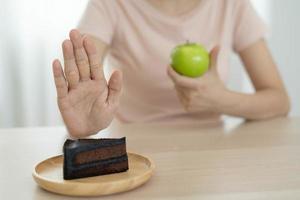 mulheres de corpo magro escolhem durante alimentos saudáveis e junk food, mulheres escolhem maçã verde para dieta. boa comida saudável. perda de peso, equilíbrio, controle, redução de gordura, baixas calorias, rotinas, exercícios. foto