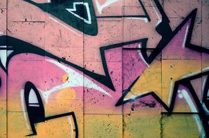 um fragmento de grafite detalhado de um desenho feito com tintas aerossol em uma parede de ladrilhos de concreto. imagem de fundo de arte de rua em tons de cor bege e rosa foto