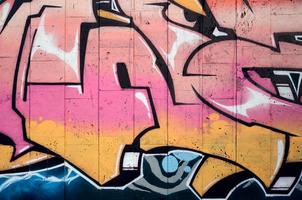 um fragmento de grafite detalhado de um desenho feito com tintas aerossol em uma parede de ladrilhos de concreto. imagem de fundo de arte de rua em tons de cor bege e rosa foto