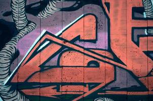 um fragmento de grafite detalhado de um desenho feito com tintas aerossol em uma parede de ladrilhos de concreto. imagem de fundo de arte de rua em tons quentes de cor vermelha foto