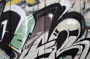 um fragmento de grafite detalhado de um desenho feito com tintas aerossol em uma parede de ladrilhos de concreto. imagem de fundo de arte de rua em tons de marrom e creme foto