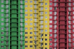 bandeira do mali retratada em cores de tinta em prédio residencial de vários andares em construção. banner texturizado no fundo da parede de tijolos foto