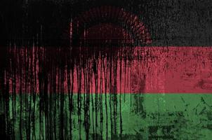 bandeira do maláui retratada em cores de tinta na parede de barril de óleo velho e sujo. banner texturizado em fundo áspero foto