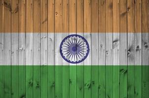 bandeira da índia retratada em cores brilhantes de tinta na parede de madeira velha. banner texturizado em fundo áspero foto