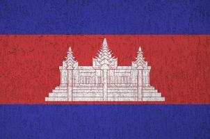 bandeira do camboja retratada em cores de tinta brilhantes na parede de reboco em relevo antigo. banner texturizado em fundo áspero foto