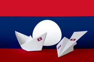 bandeira do laos retratada em barco e avião de origami de papel. conceito de artes artesanais foto