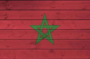 bandeira de marrocos retratada em cores de tinta brilhante na parede de madeira velha. banner texturizado em fundo áspero foto