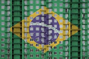 bandeira do brasil retratada em cores de tinta em prédio residencial de vários andares em construção. banner texturizado no fundo da parede de tijolos foto