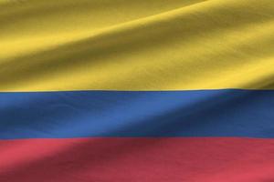 bandeira da colômbia com grandes dobras acenando perto sob a luz do estúdio dentro de casa. os símbolos e cores oficiais no banner foto