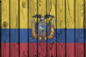 bandeira do equador retratada em cores brilhantes de tinta na parede de madeira velha. banner texturizado em fundo áspero foto