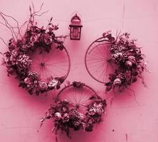 objeto de arte urbana de decoração de rodas de bicicleta e flores na imagem da parede em tons de viva magenta, cor do ano de 2023 foto