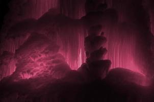 grandes blocos de gelo congelado imagem de fundo de cachoeira ou caverna tonificada em viva magenta, cor do ano 2023 foto