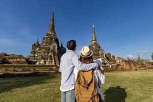 vista traseira de um casal de turistas que vem visitar o templo wat phra si sanphet, ayutthaya tailândia usando mapas para viagens, férias, férias, lua de mel e turismo foto