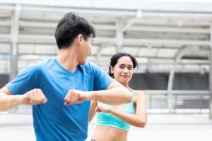 feliz e saudável homem e mulher atleta corredor se aquecem juntos antes de corrida ao ar livre e treino de corrida ou corrida na cidade foto