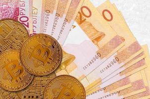 Notas de 20 rublos bielorrussos e bitcoins dourados. conceito de investimento em criptomoeda. mineração ou negociação de criptografia foto