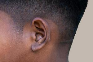 ouvido humano - perto da orelha de um homem, sua parte do corpo ajuda a ouvir as ondas sonoras.
