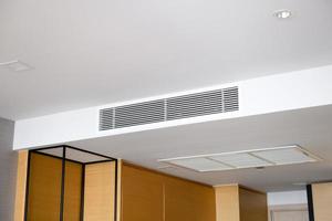 condicionador de ar tipo cassete montado no teto e luz de lâmpada moderna no teto branco. ar condicionado de duto para casa ou escritório